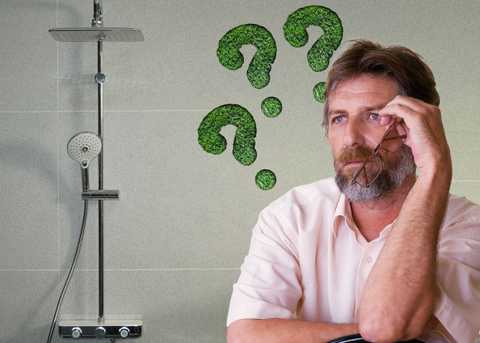 Un homme se questionnant sur l'écologie en regardant sa douche