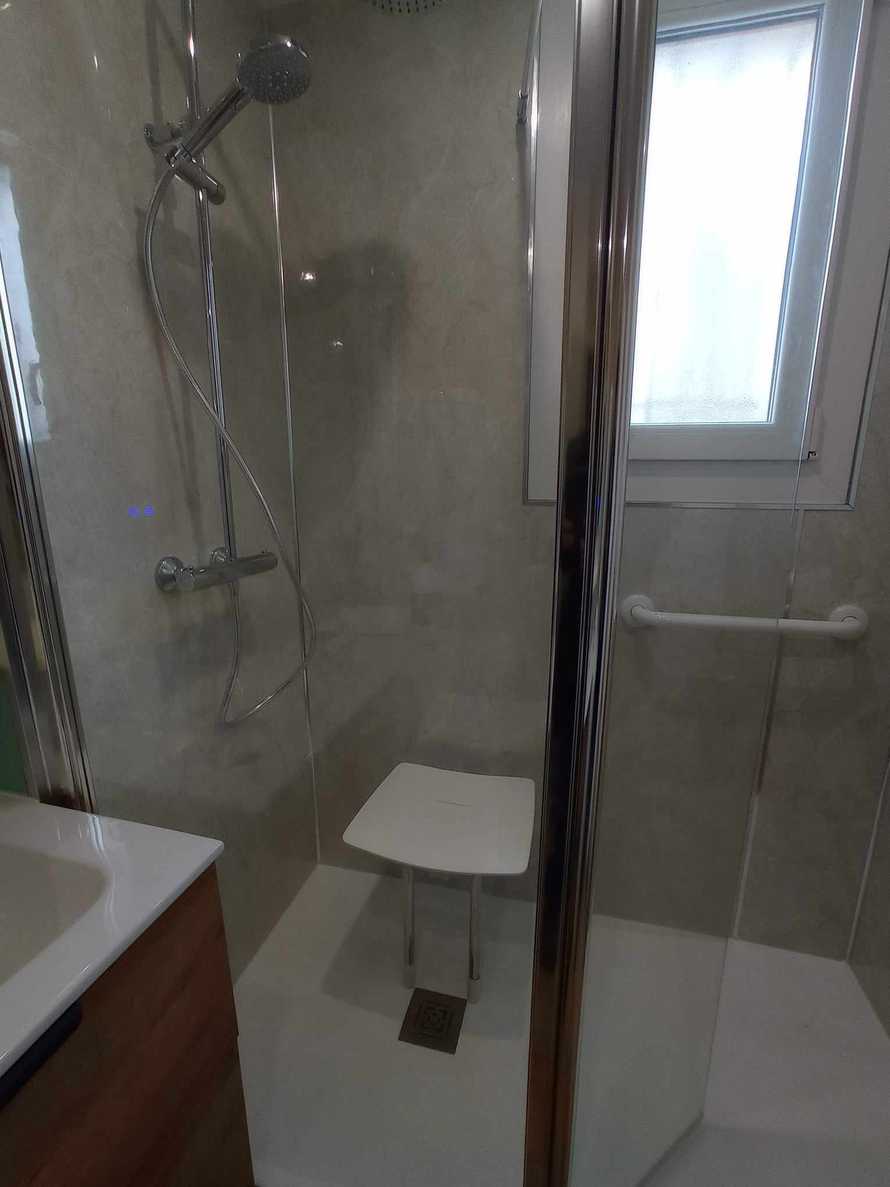 Une petite douche sécurisée avec un siège rabattable